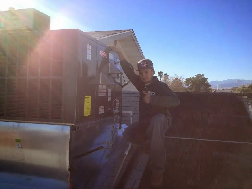 HVAC technician performing HVAC Inspection on a rooftop unit in Mont Belvieu